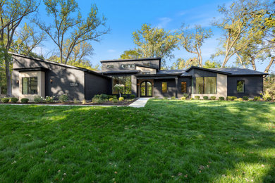 Inspiration for a large contemporary black one-story brick and board and batten house exterior remodel in Chicago with a shed roof, a shingle roof and a black roof