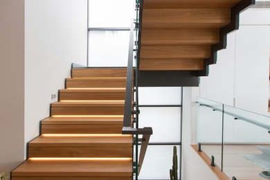 Design ideas for a mid-sized contemporary wood staircase in Newcastle - Maitland with wood risers and metal railing.
