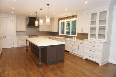Example of a large transitional u-shaped medium tone wood floor and brown floor eat-in kitchen design in DC Metro with an undermount sink, recessed-panel cabinets, gray cabinets, quartz countertops, gray backsplash, glass tile backsplash, paneled appliances, an island and white countertops