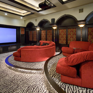 Cette image montre une salle de cinéma traditionnelle fermée avec moquette, un écran de projection et un sol multicolore.