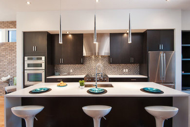 Minimalist bamboo floor kitchen photo in Calgary with flat-panel cabinets, dark wood cabinets, quartz countertops and stainless steel appliances