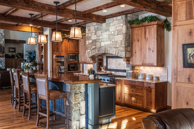 Mountain style medium tone wood floor kitchen photo in Denver with shaker cabinets, medium tone wood cabinets, wood countertops, beige backsplash, stone tile backsplash, stainless steel appliances and an island