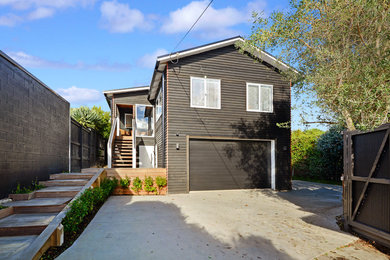 Inspiration for a contemporary black exterior in Auckland with wood siding.
