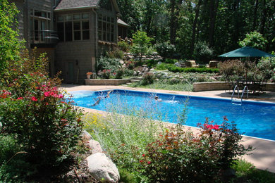 Design ideas for a traditional backyard rectangular lap pool in Other with a hot tub and concrete pavers.