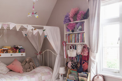 Mid-sized eclectic girl medium tone wood floor and brown floor kids' room photo in West Midlands with pink walls