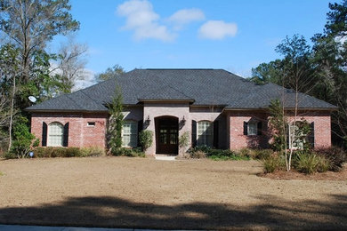 Example of a mid-sized transitional red one-story brick house exterior design in Miami with a hip roof and a shingle roof