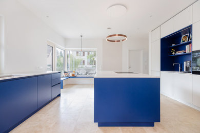 Offene, Zweizeilige, Große Moderne grifflose Küche mit Unterbauwaschbecken, flächenbündigen Schrankfronten, blauen Schränken, Quarzwerkstein-Arbeitsplatte, Küchenrückwand in Blau, schwarzen Elektrogeräten, zwei Kücheninseln, beigem Boden und weißer Arbeitsplatte in Frankfurt am Main
