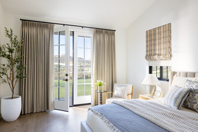Example of a mid-sized transitional master medium tone wood floor and brown floor bedroom design in Atlanta with white walls and no fireplace
