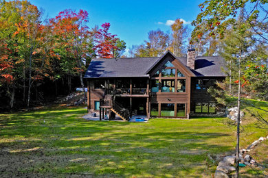 Mid-sized mountain style brown two-story wood exterior home photo in Other with a shingle roof and a gray roof