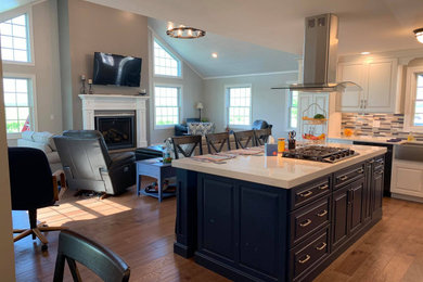 Inspiration for a mid-sized farmhouse l-shaped medium tone wood floor and brown floor eat-in kitchen remodel in Other with a farmhouse sink, raised-panel cabinets, blue cabinets, quartz countertops, multicolored backsplash and white countertops