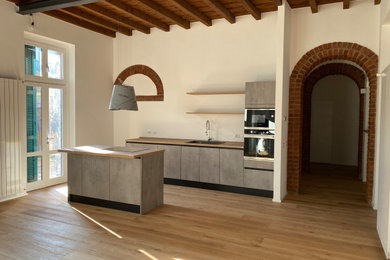 Esempio di una cucina design di medie dimensioni con lavello a vasca singola, ante lisce, ante grigie, top in legno, parquet chiaro e travi a vista