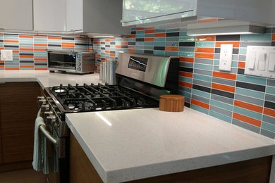Example of a large trendy l-shaped open concept kitchen design in San Francisco with flat-panel cabinets, white cabinets, quartzite countertops, multicolored backsplash, glass tile backsplash, stainless steel appliances and an island