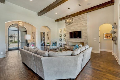 Inspiration for a mediterranean medium tone wood floor family room remodel in Dallas with a tile fireplace and a wall-mounted tv