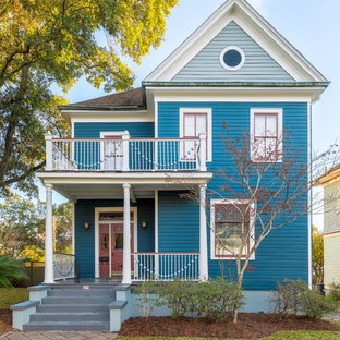 Удачное сочетание для дизайна помещения: большой фасад частного дома синего цвета в викторианском стиле с облицовкой из дерева, двускатной крышей и крышей из гибкой черепицы - самое интересное для вас