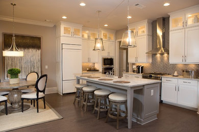 Inspiration for a mid-sized transitional u-shaped dark wood floor enclosed kitchen remodel in Atlanta with an undermount sink, shaker cabinets, white cabinets, quartz countertops, gray backsplash, ceramic backsplash, stainless steel appliances and an island