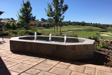 This is an example of a large traditional backyard full sun formal garden in Sacramento with a water feature and natural stone pavers.