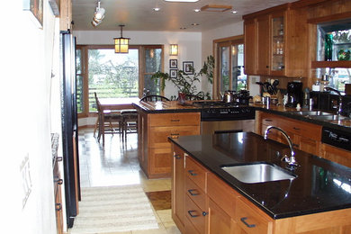 Inspiration for a large contemporary u-shaped travertine floor eat-in kitchen remodel in Other with a drop-in sink, recessed-panel cabinets, medium tone wood cabinets, granite countertops, black backsplash, stone tile backsplash, paneled appliances and an island