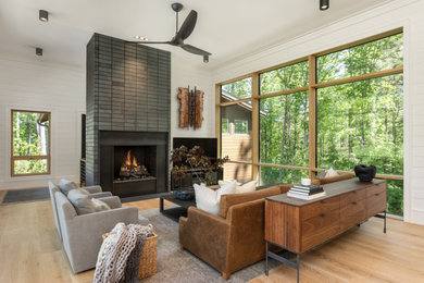 Large transitional open concept light wood floor and shiplap wall living room photo in Other with a standard fireplace