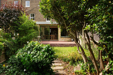 Photo of a medium sized contemporary patio in London with brick paving.