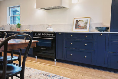 Eat-in kitchen - large transitional l-shaped medium tone wood floor and brown floor eat-in kitchen idea in Other with an undermount sink, shaker cabinets, blue cabinets, quartzite countertops, stone slab backsplash, paneled appliances, no island and gray countertops