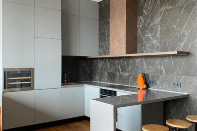 Photo of a small urban grey and brown u-shaped open plan kitchen in Moscow with a submerged sink, flat-panel cabinets, grey cabinets, composite countertops, black splashback, ceramic splashback, stainless steel appliances, medium hardwood flooring, orange floors, grey worktops and feature lighting.