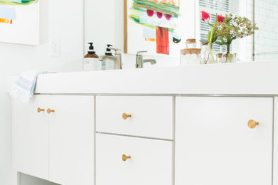 Inspiration for a modern kids' white tile and subway tile ceramic tile bathroom remodel in Cedar Rapids with flat-panel cabinets, white cabinets, a two-piece toilet, white walls, an integrated sink and solid surface countertops