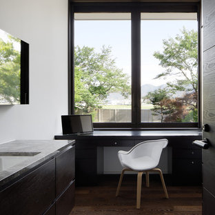 他の地域のモダンスタイルのおしゃれなホームオフィス・仕事部屋 (白い壁、濃色無垢フローリング、造り付け机、茶色い床) の写真