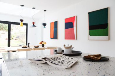 Mid-sized minimalist u-shaped eat-in kitchen photo in Kent with quartz countertops, white appliances and an island