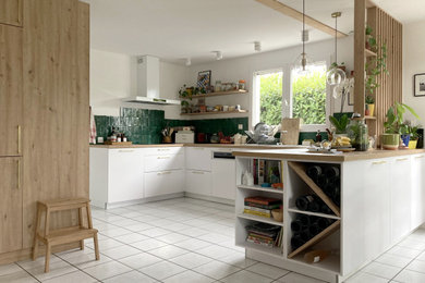 Exemple d'une cuisine ouverte encastrable nature en U de taille moyenne avec un évier encastré, un placard à porte affleurante, des portes de placard blanches, un plan de travail en bois, une crédence verte, une crédence en céramique, aucun îlot, un plan de travail marron et fenêtre au-dessus de l'évier.