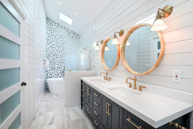 Inspiration for a mid-sized coastal master multicolored tile gray floor, double-sink, vaulted ceiling and shiplap wall bathroom remodel in Other with blue cabinets, white walls, an undermount sink, quartz countertops, white countertops, a freestanding vanity and recessed-panel cabinets