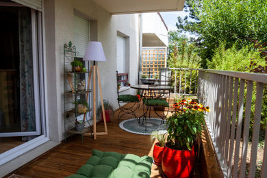 リヨンにある低価格の小さなトロピカルスタイルのおしゃれな庭のデッキ (コンテナガーデン、木材の手すり) の写真