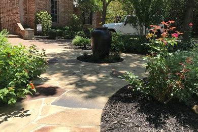 Inspiration for a mid-sized traditional partial sun front yard stone water fountain landscape in Dallas.