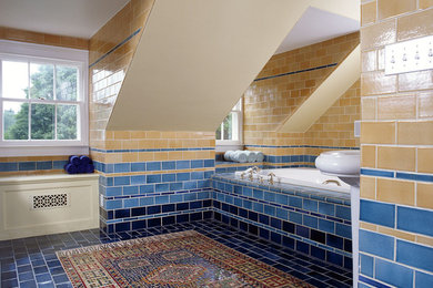 Contemporary bathroom in Santa Barbara with multi-coloured tile, subway tile, an alcove tub and blue floor.