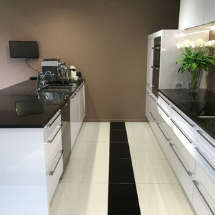 Идея дизайна: угловая кухня среднего размера в современном стиле с кладовкой, врезной раковиной, белыми фасадами, столешницей из гранита, коричневым фартуком, техникой из нержавеющей стали, полом из керамогранита, островом и желтым полом