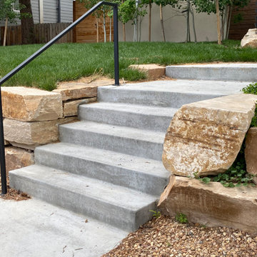 Mountain inspired minimalist boulder retaining walls and plantings.