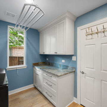 Modern laundry room interior with white cabinetry and gold-veined quartz counter
