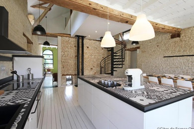 Inspiration for a large galley eat-in kitchen in Paris with an undermount sink, beaded inset cabinets, white cabinets, tile benchtops, black splashback, cement tile splashback, painted wood floors, with island, white floor, black benchtop and black appliances.