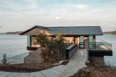Large transitional two-story house exterior photo in Toronto with a metal roof and a black roof