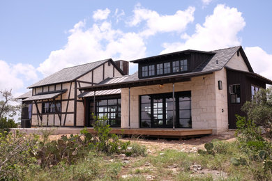 Inspiration for a large eclectic beige one-story stone exterior home remodel in Austin with a brown roof