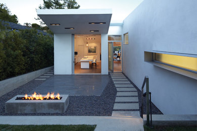 Mid-sized modern front yard partial sun garden in Los Angeles with a fire feature and concrete pavers.