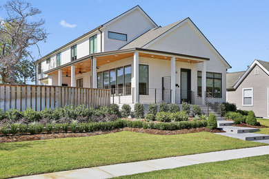 Inspiration for a mid-sized modern white two-story stucco house exterior remodel in New Orleans with a shingle roof and a gray roof