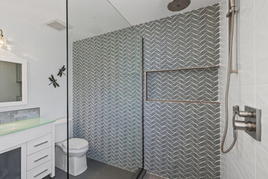 Inspiration for a large modern master multicolored tile and porcelain tile mosaic tile floor and brown floor bathroom remodel in Phoenix with flat-panel cabinets, white cabinets, a two-piece toilet, glass countertops, a niche and a built-in vanity