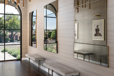 Huge transitional dark wood floor, brown floor and wallpaper entryway photo in Phoenix with brown walls and a black front door