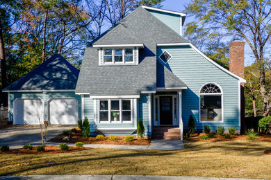 Example of a mid-sized trendy blue two-story wood house exterior design in Orange County with a hip roof and a shingle roof