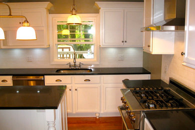 Enclosed kitchen - mid-sized modern u-shaped medium tone wood floor enclosed kitchen idea in Philadelphia with white cabinets, white backsplash, stainless steel appliances and an island