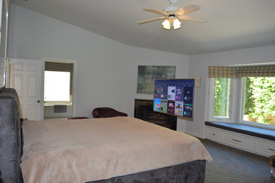 Imagen de dormitorio principal clásico de tamaño medio con paredes blancas, moqueta, chimenea de esquina, marco de chimenea de metal y suelo gris
