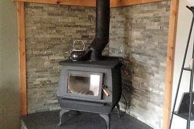Imagen de salón actual pequeño con chimenea de esquina y piedra de revestimiento