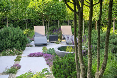 Foto de jardín minimalista de tamaño medio en patio trasero con exposición parcial al sol y adoquines de piedra natural