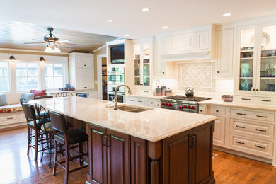 Inspiration for a mid-sized traditional single-wall eat-in kitchen in Louisville with a double-bowl sink, raised-panel cabinets, white cabinets, marble benchtops, white splashback, ceramic splashback, panelled appliances, medium hardwood floors and with island.