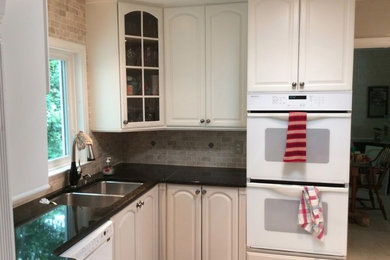 Inspiration for a small contemporary slate floor kitchen remodel in DC Metro with a double-bowl sink, white appliances and black countertops